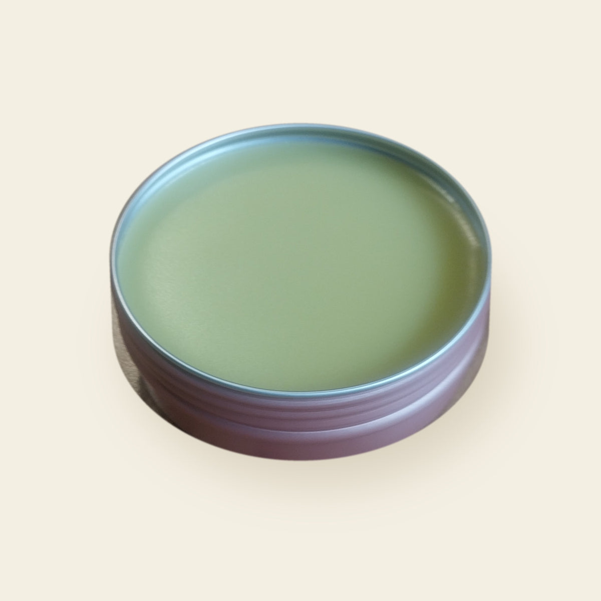 Melzayta Body Balm in a rose-gold tin, seen from an angle