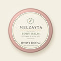 Melzayta Body Balm: closed rose-gold tin with the cream Body Balm label, beeswax and olive oil, 2 oz